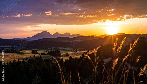 Sunset over hills, grass in foreground