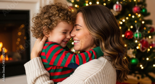 Close up happy young mother hugging child son near christmas tree. Happy family having happy time together on Christmas.