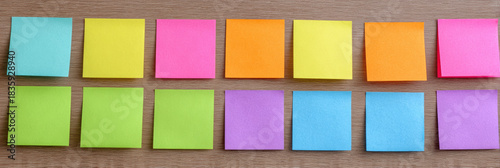 Vibrant collection of colorful sticky note paper arranged in organized rows. These bright, neon adhesive memo pads evoke creative feeling for any reminder or message