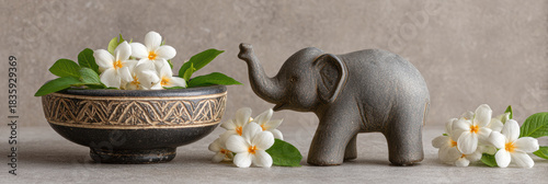 Calm elephant figurine decoration with fresh white jasmine flower in ceramic bowl. still life concept for spa, wellness, and tranquility creating peaceful atmosphere