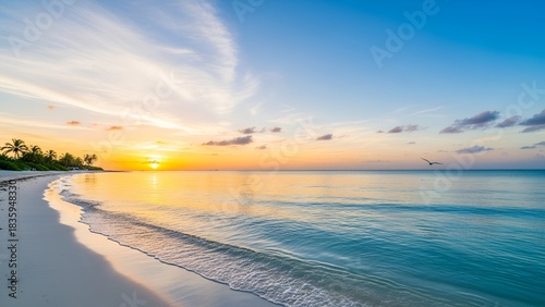 Sunrise over serene beach with clear turquoise water and a golden sky