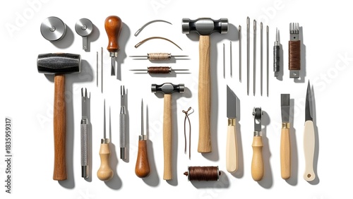 Overhead shot of leatherworking tools arranged neatly on a white surface, natural light