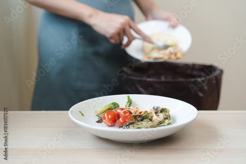 Wallpaper Mural The housewife is throwing the leftover food from the meal into the bin Torontodigital.ca
