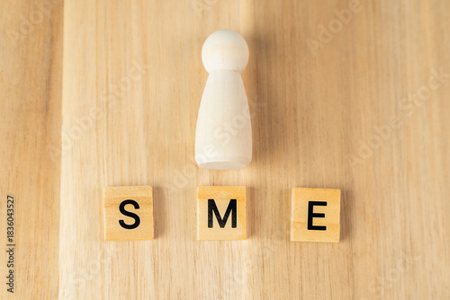 Foto Small business, SME text on wooden cube block background.