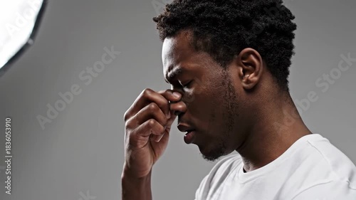 Serious Black Man Portrait Experiencing Difficulty and Pressure Showing Distress in Studio