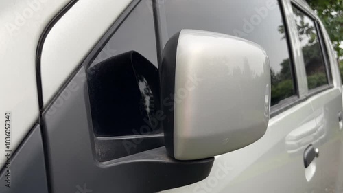 Close up of silver car side mirror and clear reflection with black plastic base