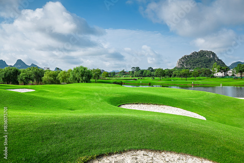 Foto Green golf course field with sand bunkers and lake in summer.