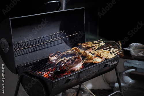 Grilling seafood such as squid and lobster over open flame for dinner preparation — fresh cooking process and flavorful outdoor cuisine