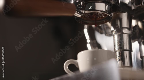 Slow motion first drops of espresso pour with naked portafileter