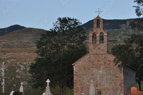 Church stands against a serene mountain backdrop at dusk in a quiet countryside