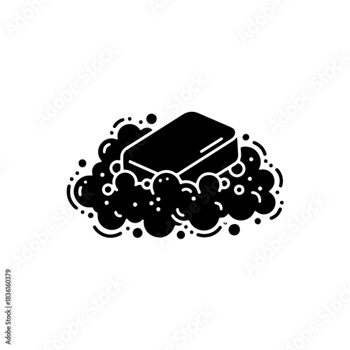 Black and white solid silhouette icon of a bar of soap resting on a pile of foam or bubbles. Clean vector illustration representing hygiene, bathing, and cleaning products