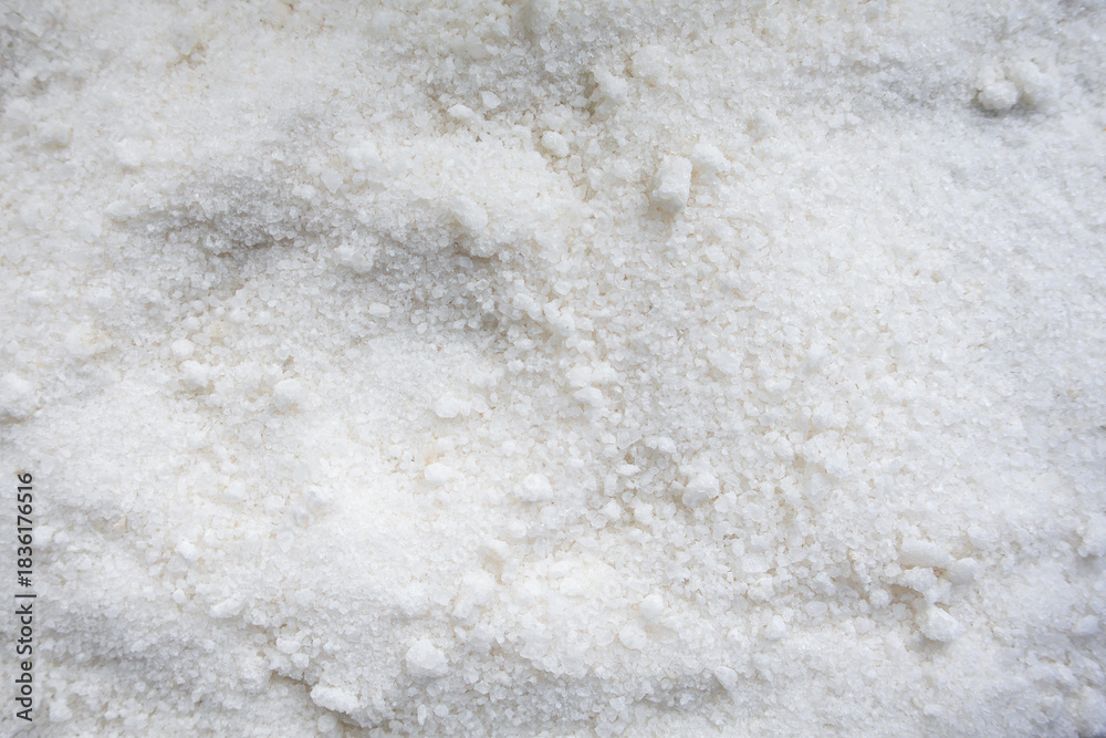 Obraz premium A close-up texture shot of white table salt crystals forming a granular mound, highlighting the crystalline shapes and fine detail of each grain.