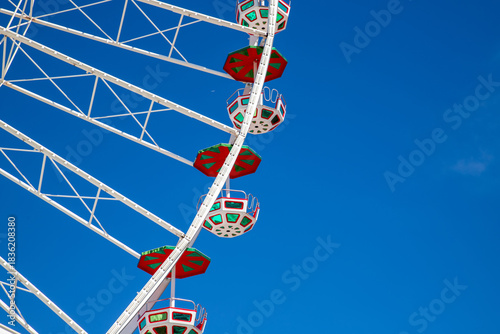 a section of a large Ferris wheel set against a clear blue sky