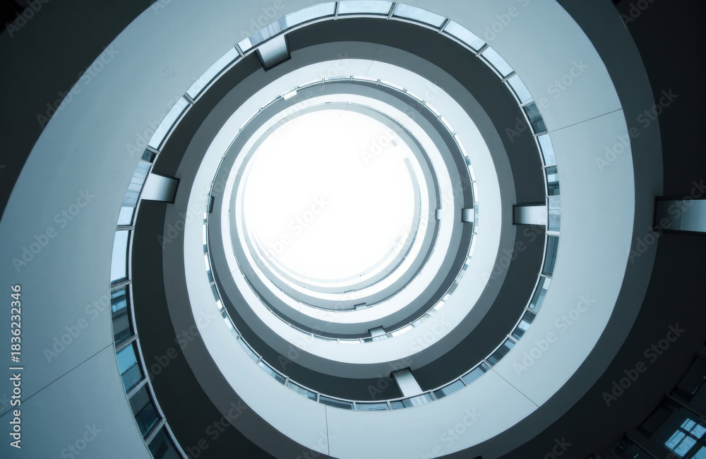 Fototapeta premium Spiral atrium with concentric balconies and round skylight overhead in blue