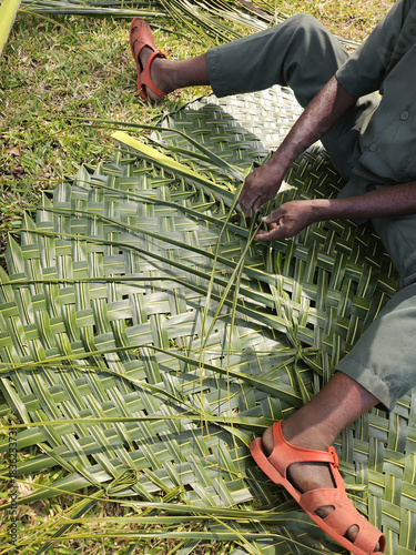 Gardener preparing mats from palm trees in tropical areas. Organic and sustainable agriculture and production.