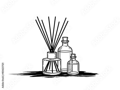 Reed diffuser beside glass oil bottles 