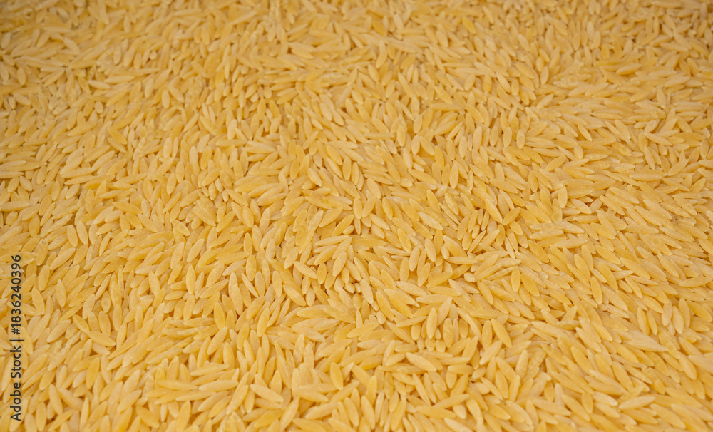 Obraz premium Raw orzo pasta, risoni or kritharaki pile