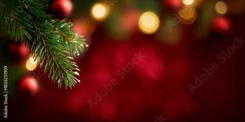 Weihnachtlicher Hintergrund mit Tannenzweig und Bokeh-Lichtern in Rot