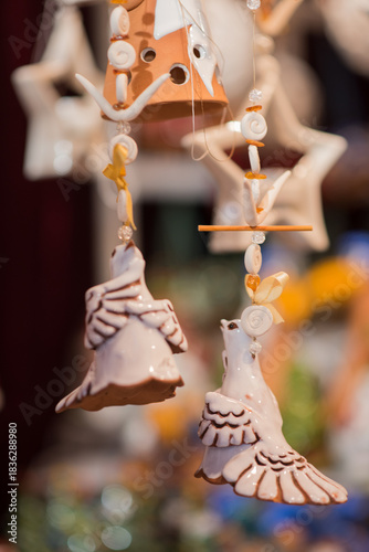 Christmas tree decoration,Close-up of delicate ceramic dove or bird ornaments hanging on beaded strings. Traditional, handcrafted Christmas decoration at the German market