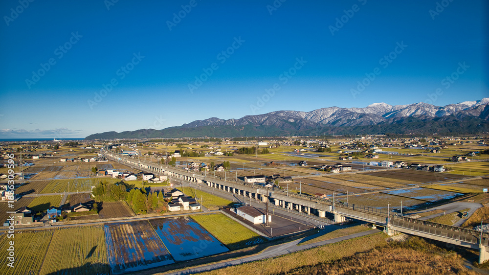 Fototapeta premium 北アルプスは雪化粧をしている12月上旬の日本の富山県東部にある黒部川扇状地