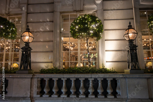 Walking on streets of Central London in Covent Garden decorated with Christmas lighting and green Christmas trees with garlands, December holidays in England