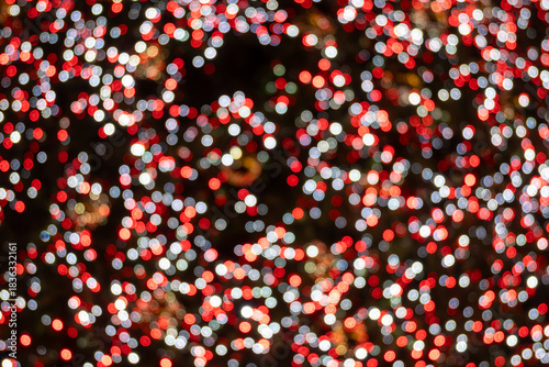 Festive dark theme with red background decorated with Christmas lighting, balls, green Christmas trees with garlands, December holidays in England