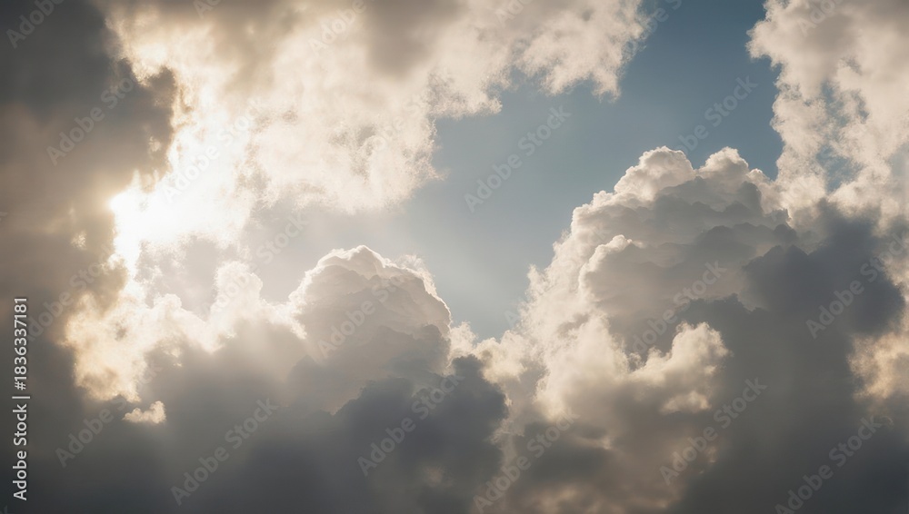Obraz premium Dramatic Sunbeams Breaking Through Cumulus Clouds in a Blue Sky.