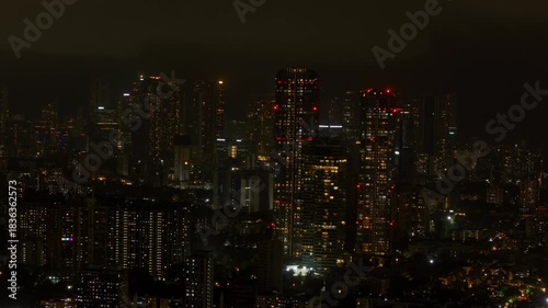 Wallpaper Mural An aerial view of Mumbai's high-rise buildings and beautiful nightlights. The sky is cloudy, and there is medium traffic on the road. The cityscape is filled with modern illuminated buildings. Torontodigital.ca
