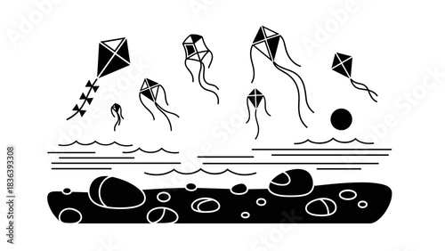 Black and white kite festival over ocean waves and rocky shoreline