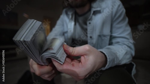 Hands performing a money fanning gesture with thick dollar stacks expressing wealth profit and make money. Hands Holding Cash, Wealth and Income concept. Money Thumbing with Financial Success