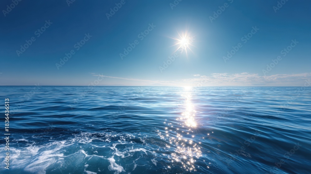 Obraz premium The sun is shining on the ocean, creating a beautiful and serene scene. The water is calm and the sky is clear, making for a perfect day to be out on the water