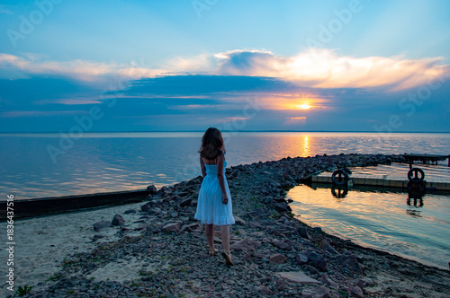 Romantic woman at sunset sea beach in summer. Woman at sea sunrise. Sunset beach and sky with seascape. Summer sea beach sunrise. Girl at romantic sunset horizon. Silhouette girl sunrise