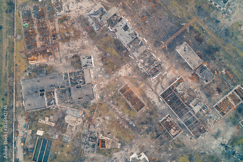 Aerial top down view of completely destroyed city buildings and industrial ruins. War invasion aftermath and apocalyptic urban infrastructure texture.
