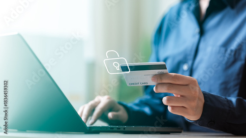 person holding credit card while using laptop, illustration secure online payments, fraud prevention, digital banking protection in modern and safe financial environment. Card freeze and lock controls