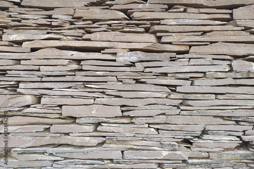 Natural stone wall. Flagstone masonry. Stone texture, gray background.