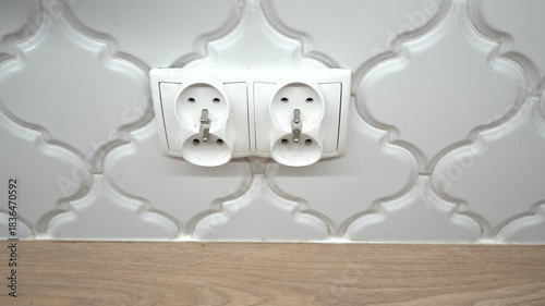 White electrical outlets on a decorative tile wall in a modern kitchen