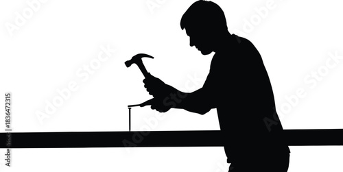 Silhouette of a construction worker or carpenter hammering a nail into a piece of wood