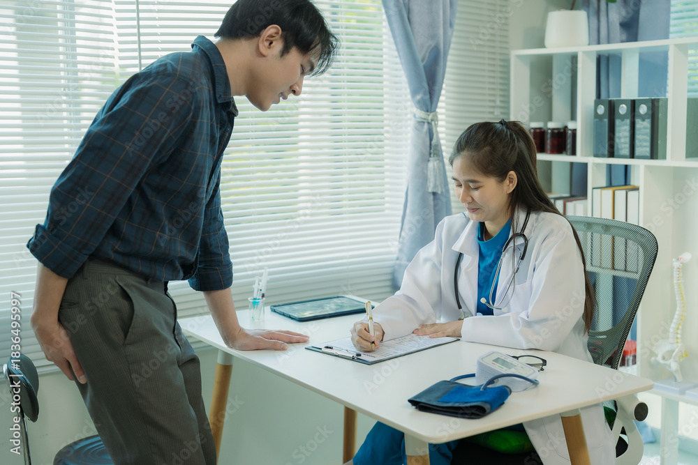 Obraz premium A man is consulting an Asian female doctor about hemorrhoids. He squeezes his buttocks. See a specialist in rectal surgery. Treatment concept.