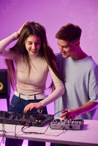 Music creators in studio, Studio session featuring musical synthesis and focused teamwork, Electronic music producers working together with various tools and instruments