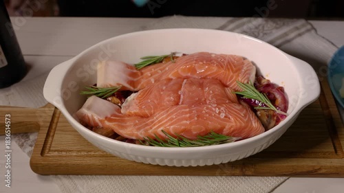 Chef seasoning raw salmon fillets for baking