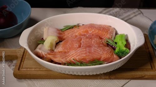 Woman preparing salmon and chicken for baking