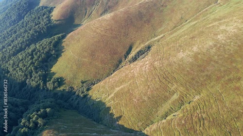 Aerial view of a mountain range landscape dotted with many trails made by flocks of sheep