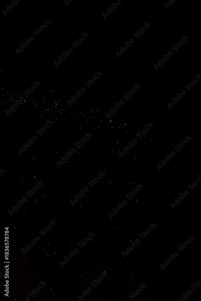 Obraz premium Sparse band of pale dust specks stretching across deep black void, tiny particles glimmering like a distant galaxy, forming a minimalist abstract night sky filled with subtle cosmic texture