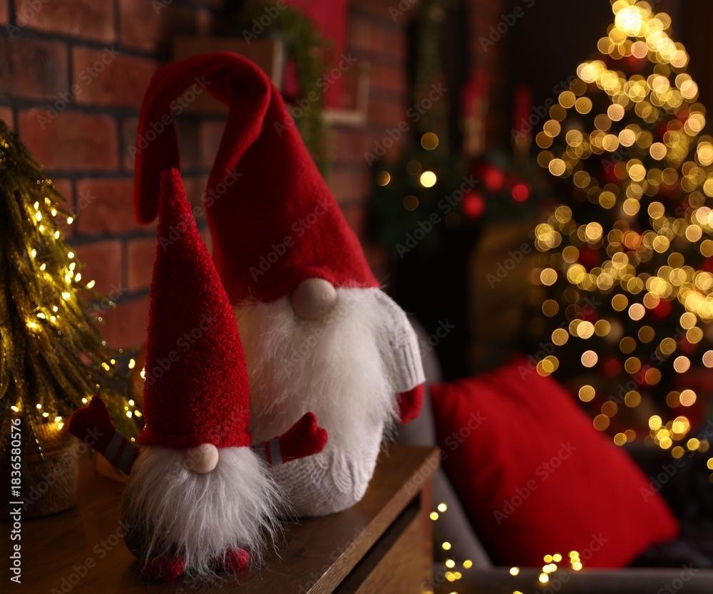 Obraz premium Funny Christmas gnomes on cabinet in decorated room, closeup