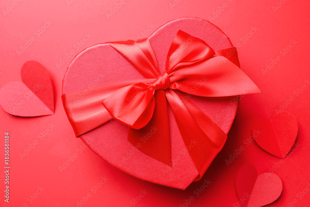 Naklejka premium Happy Valentine's Day. Heart shaped gift box and paper hearts on red background, flat lay