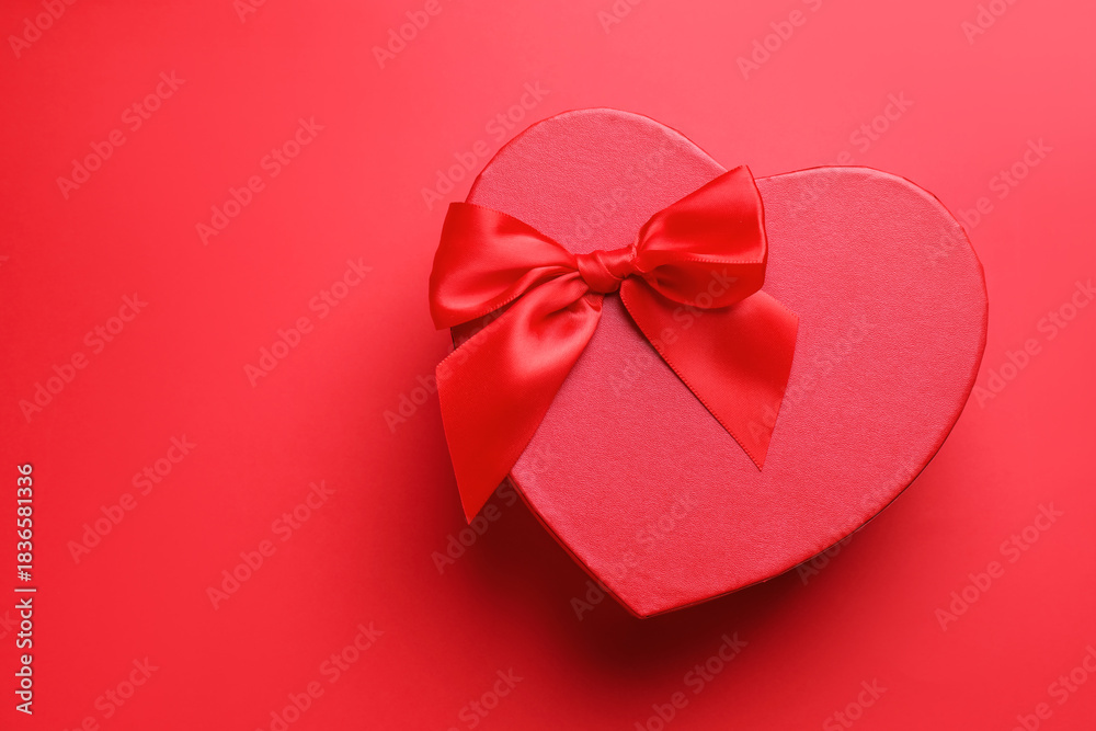Naklejka premium Happy Valentine's Day. Heart shaped gift box on red background, top view. Space for text
