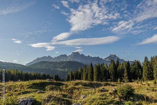 vista panoramica da Sella di Razzo, nel territorio di Vigo di Cadore, guardando verso le lontane catene montuose del Monte Lastroni, di pomeriggio, in autunno, con cielo sereno e colori brillanti