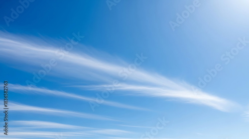 Wispy cirrus clouds streaking across a bright blue sky