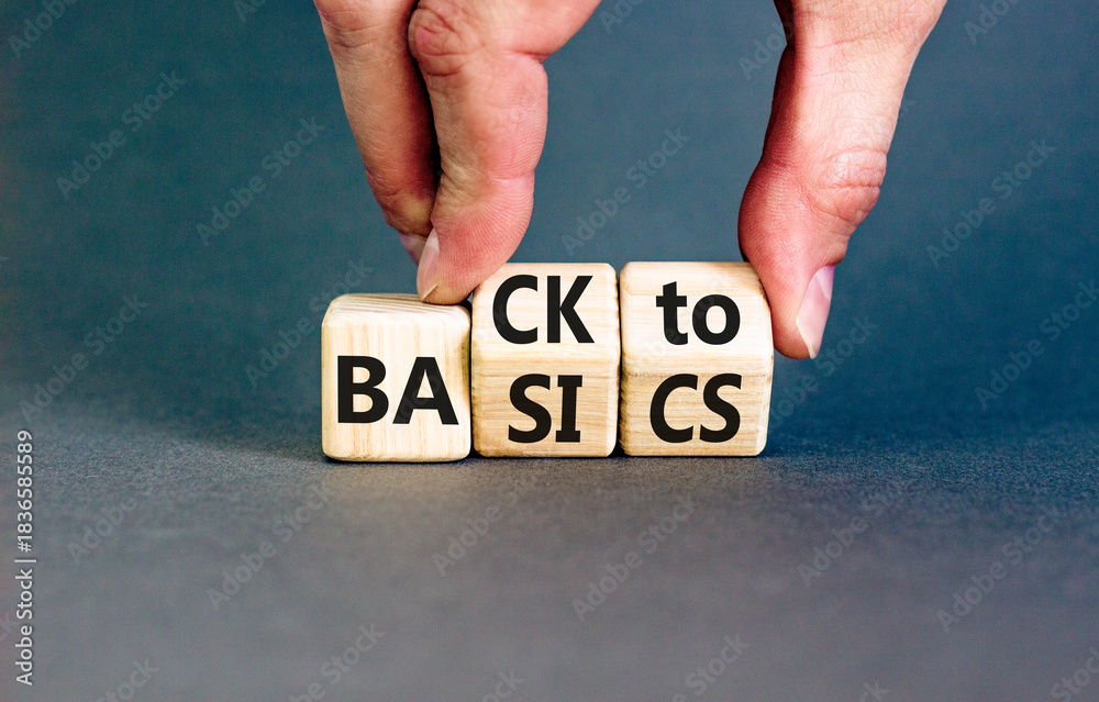 Fototapeta premium Back to basics symbol. Concept words Back to basics on wooden block. Beautiful grey table grey background. Businessman hand. Business back to basics concept. Copy space.