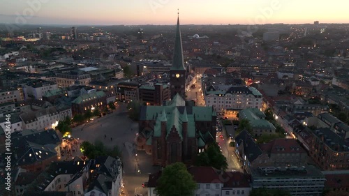 Aerial orbiting shot of the historic Aarhus Cathedral at dusk in central Aarhus, Denmark.	
